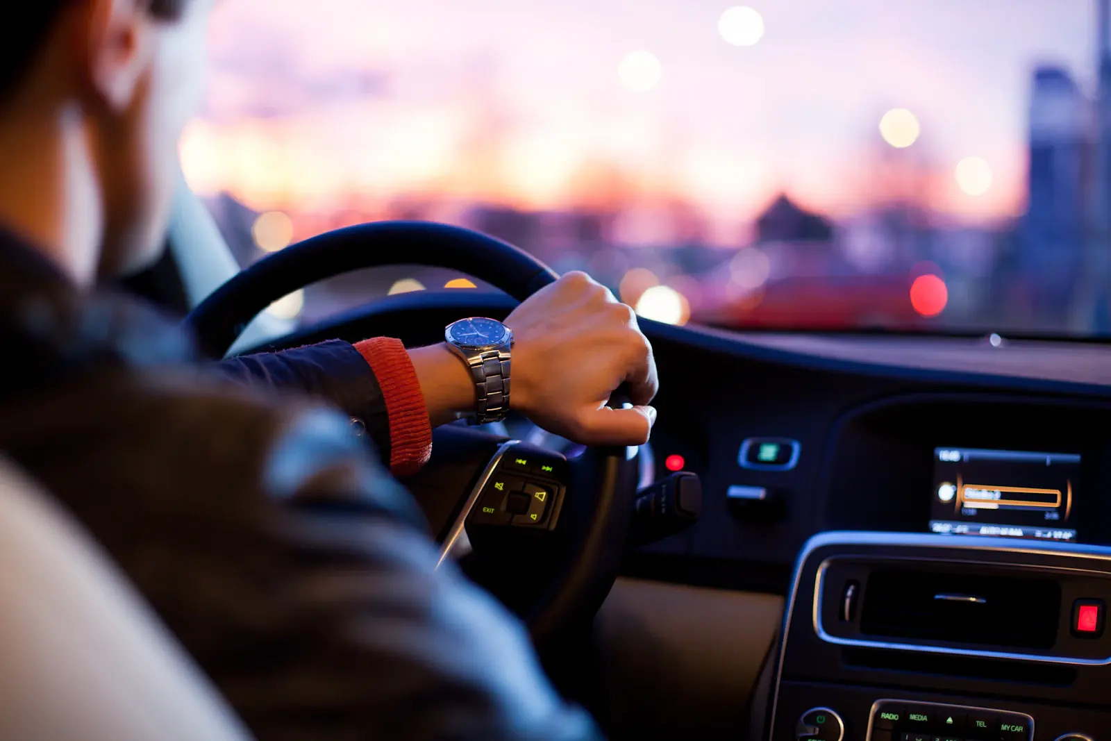 A chauffeur’s hands on the steering wheel during a drive